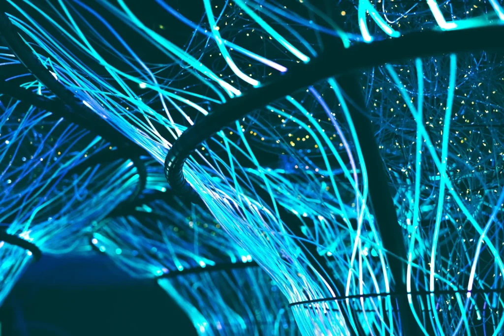 Glowing blue optical fibers against a dark background