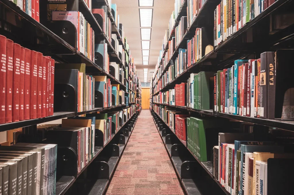 Long library aisle between tall shelves full of books
