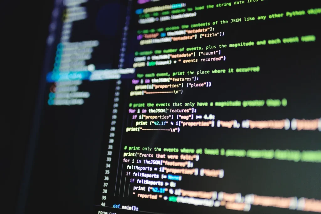 Cod de program pe un monitor întunecat, în prim-plan